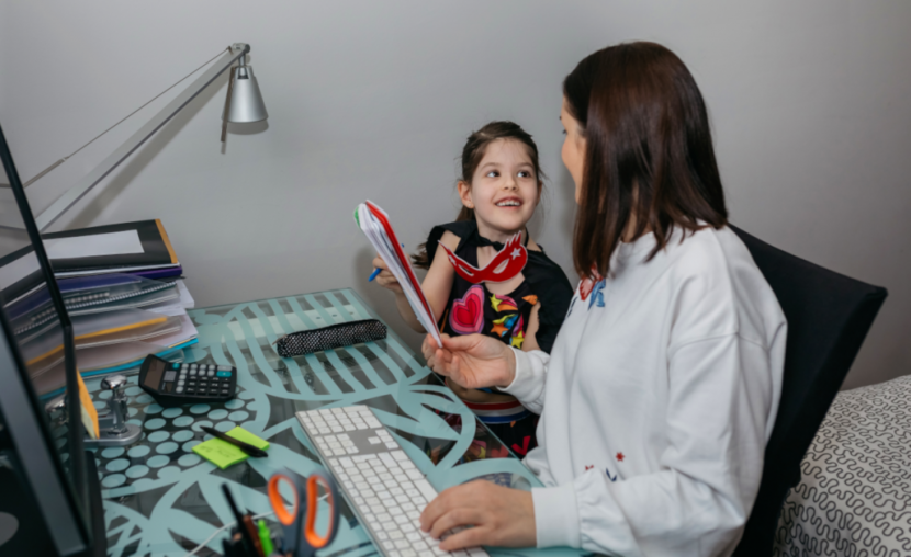 A woman is working remote and mobile at home with Laserfiche. Her daughter is asking her a question.